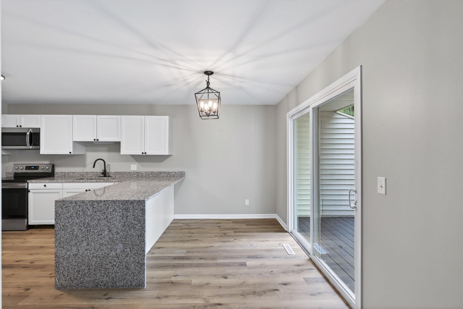 Renovated kitchen with granite waterfall countertops and updated lighting.