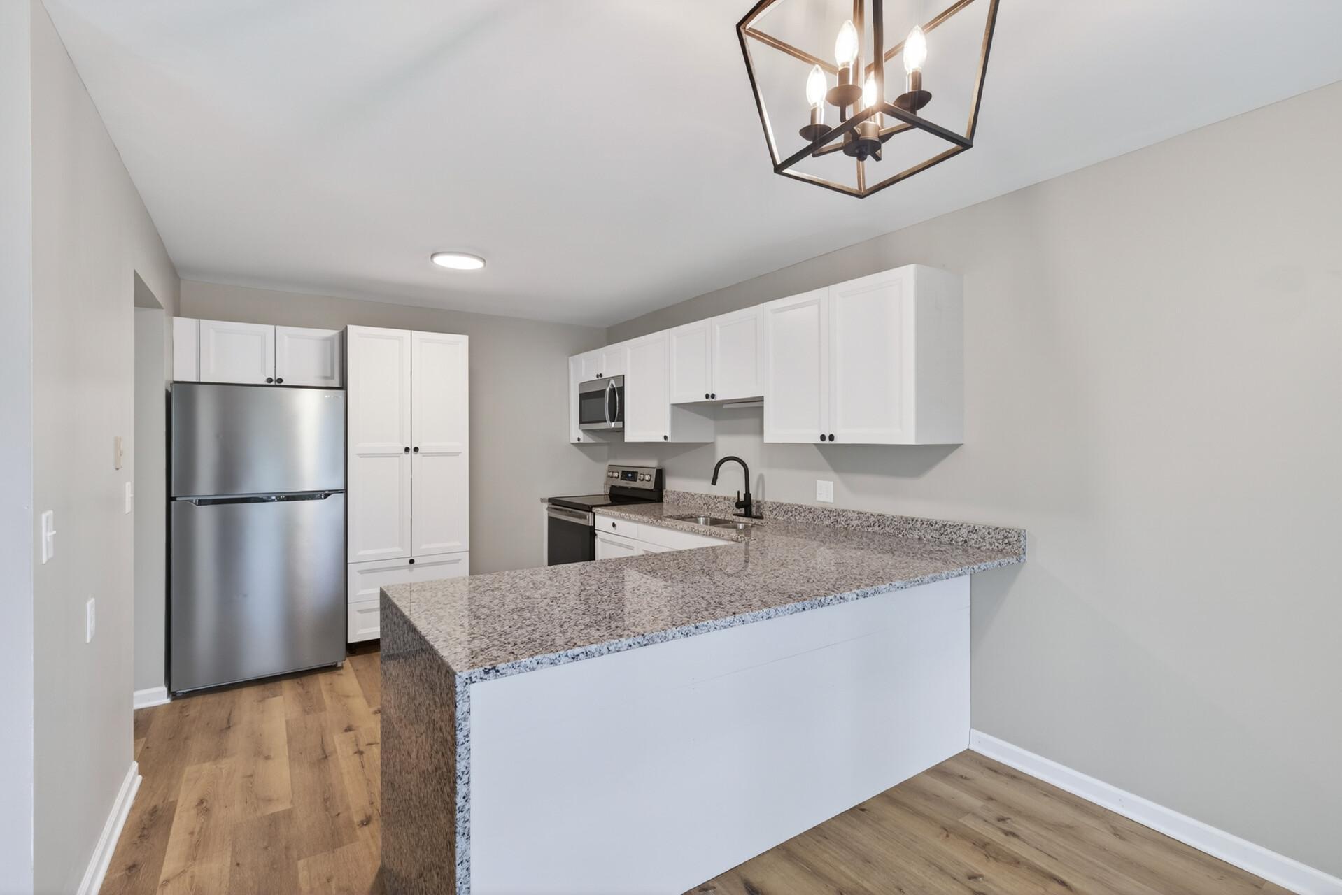 Completely updated kitchen featuring white cabinetry and stainless steel appliances.
