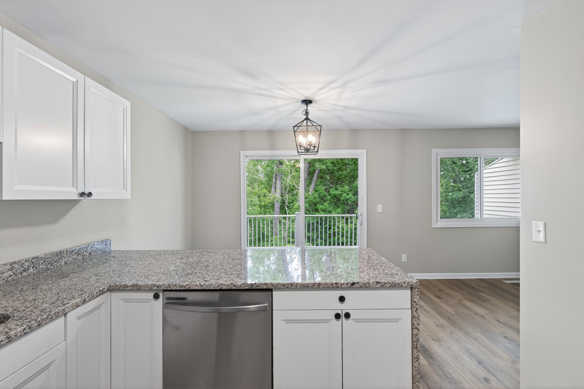 Kitchen and dining space with wooded views and access to the private deck