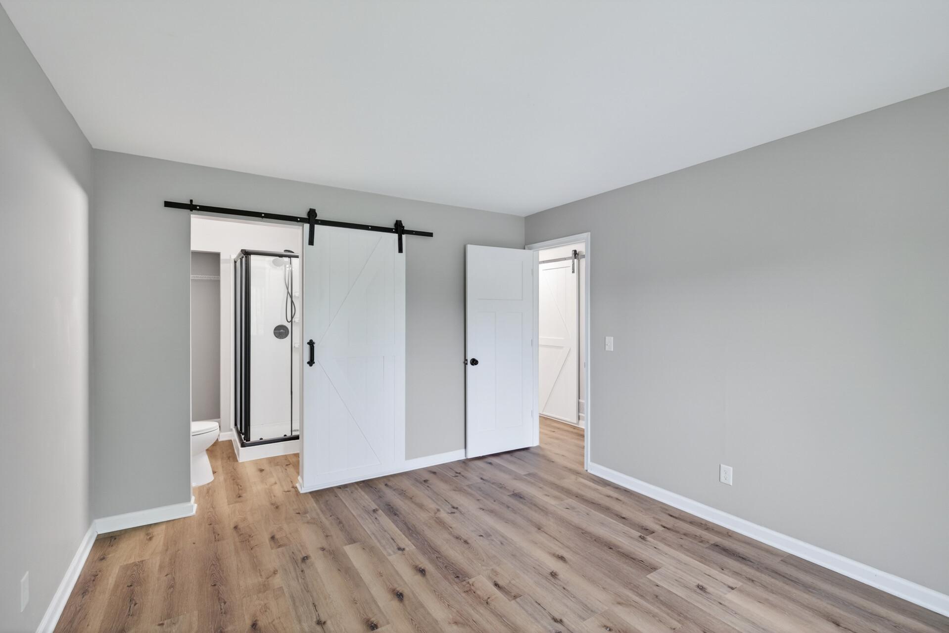 Spacious primary suite featuring updated flooring and direct access to the ensuite bath.