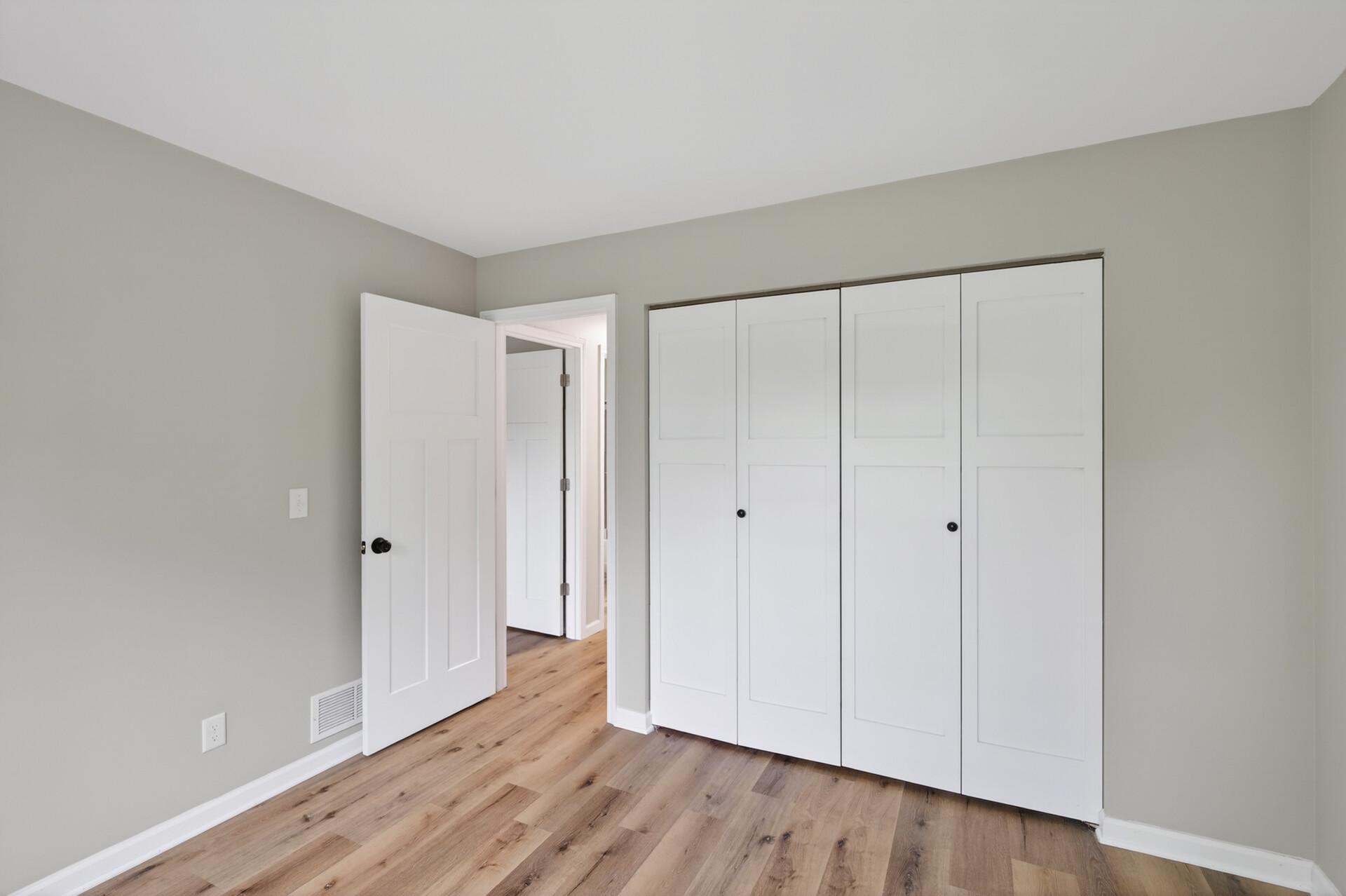 Comfortable guest bedroom with new closet doors and LVP flooring.