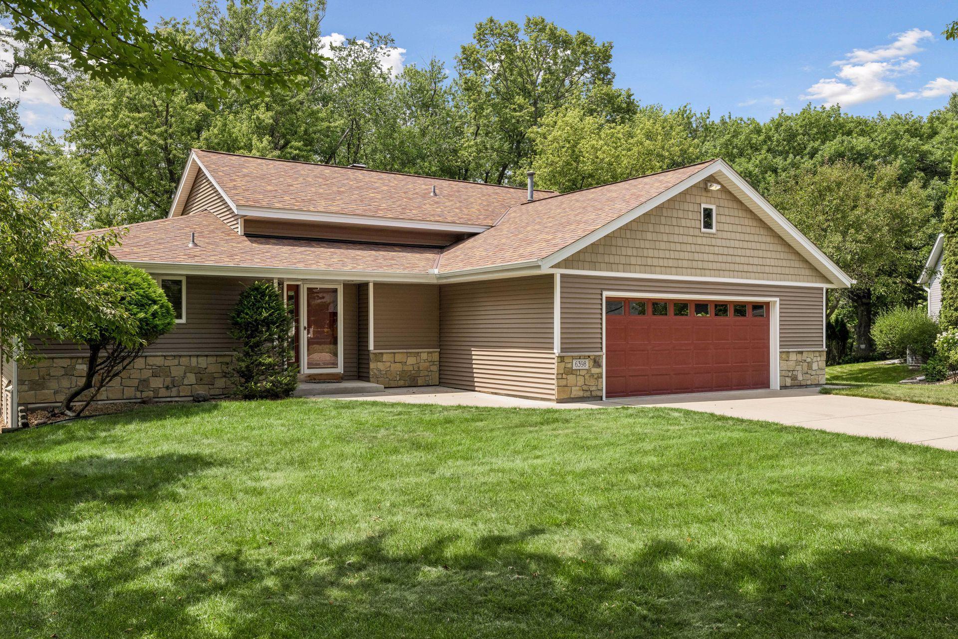 Crisp and clean exterior with updated siding, roof, windows, concrete driveway and garage door.