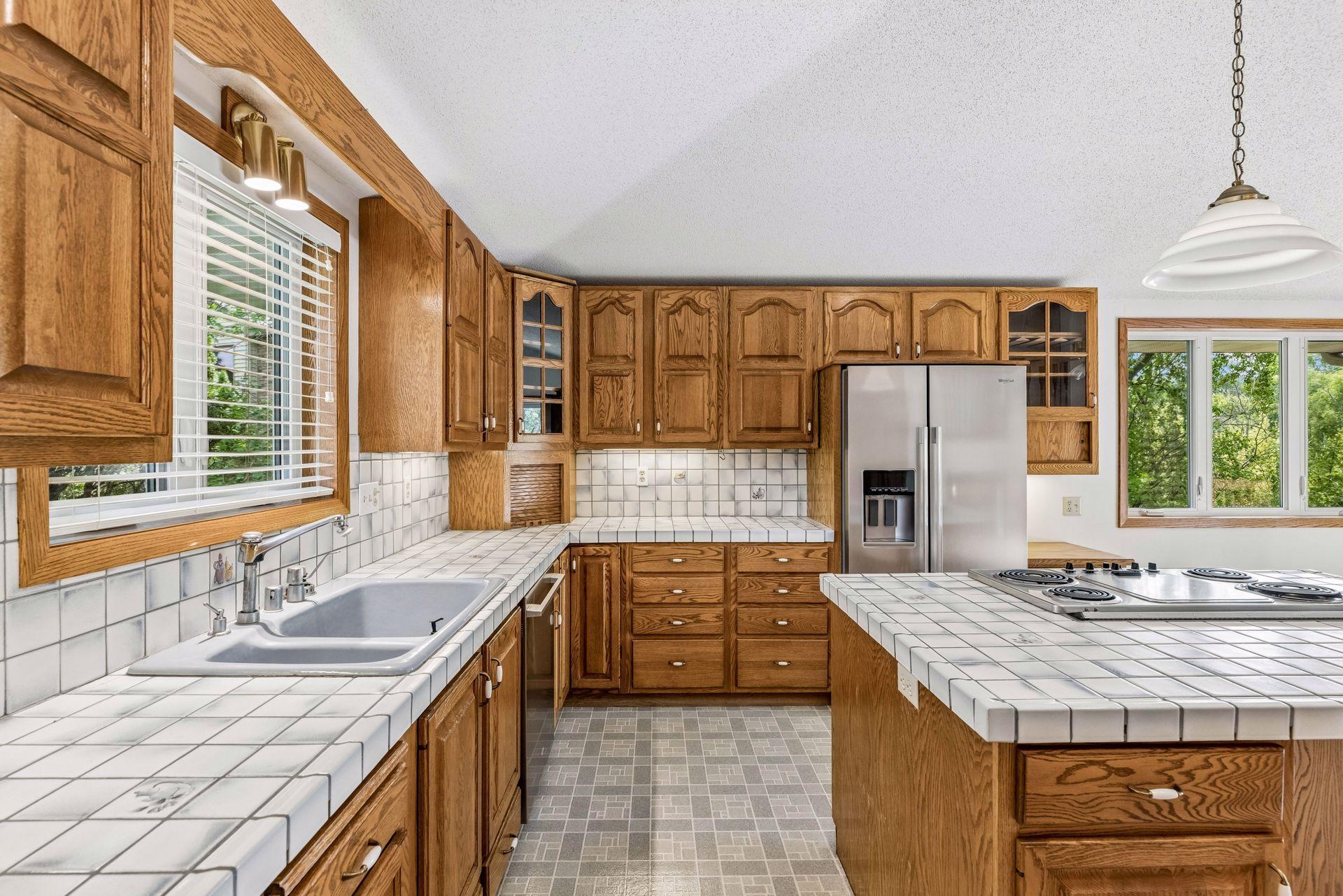 Very spacious kitchen features custom cabinetry with built-ins, center island with cooktop, vaulted ceiling, and stainless appliances.