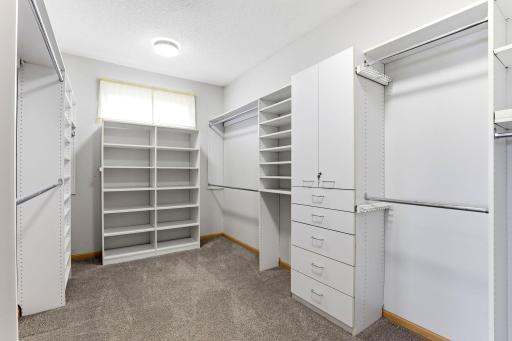 Walk in closet in primary bedroom has generous space and many built ins.