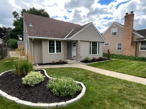 Welcome home to this picture-perfect property! Boasting incredible curb appeal, this beautifully updated home features pristine neutral siding, custom brick porch accents, and professional stone-edged landscaping. A concrete walkway invites you into