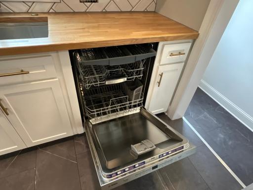 This premium Bosch dishwasher features a high-capacity, three-rack design with top-of-door integrated controls for a seamless, handle-free look