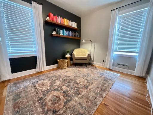 Used as an office and library, this room on the main floor features custom window coverings which are throughout the home.