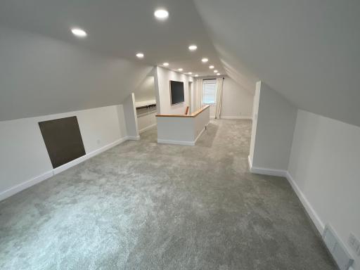 This expansive, fully finished bonus space features plush carpeting and custom architectural lines, perfect for a private primary suite, home theater, or playroom.