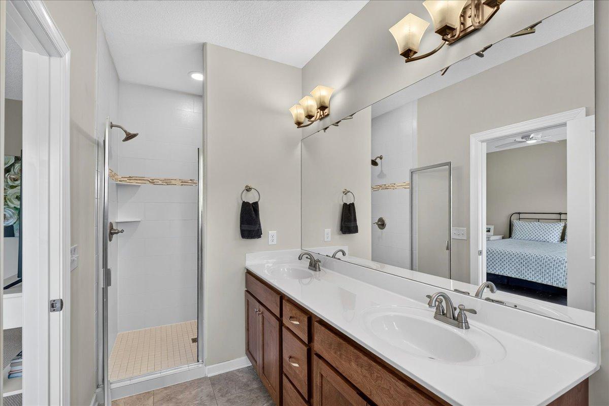 Private ensuite 3/4 bathroom with walk-in tile shower and double vanity