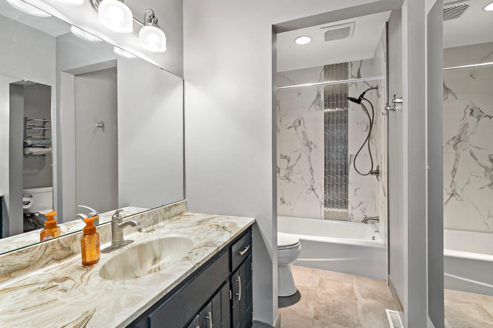The upper level bath includes a tub with full ceramic tile surround and tile flooring