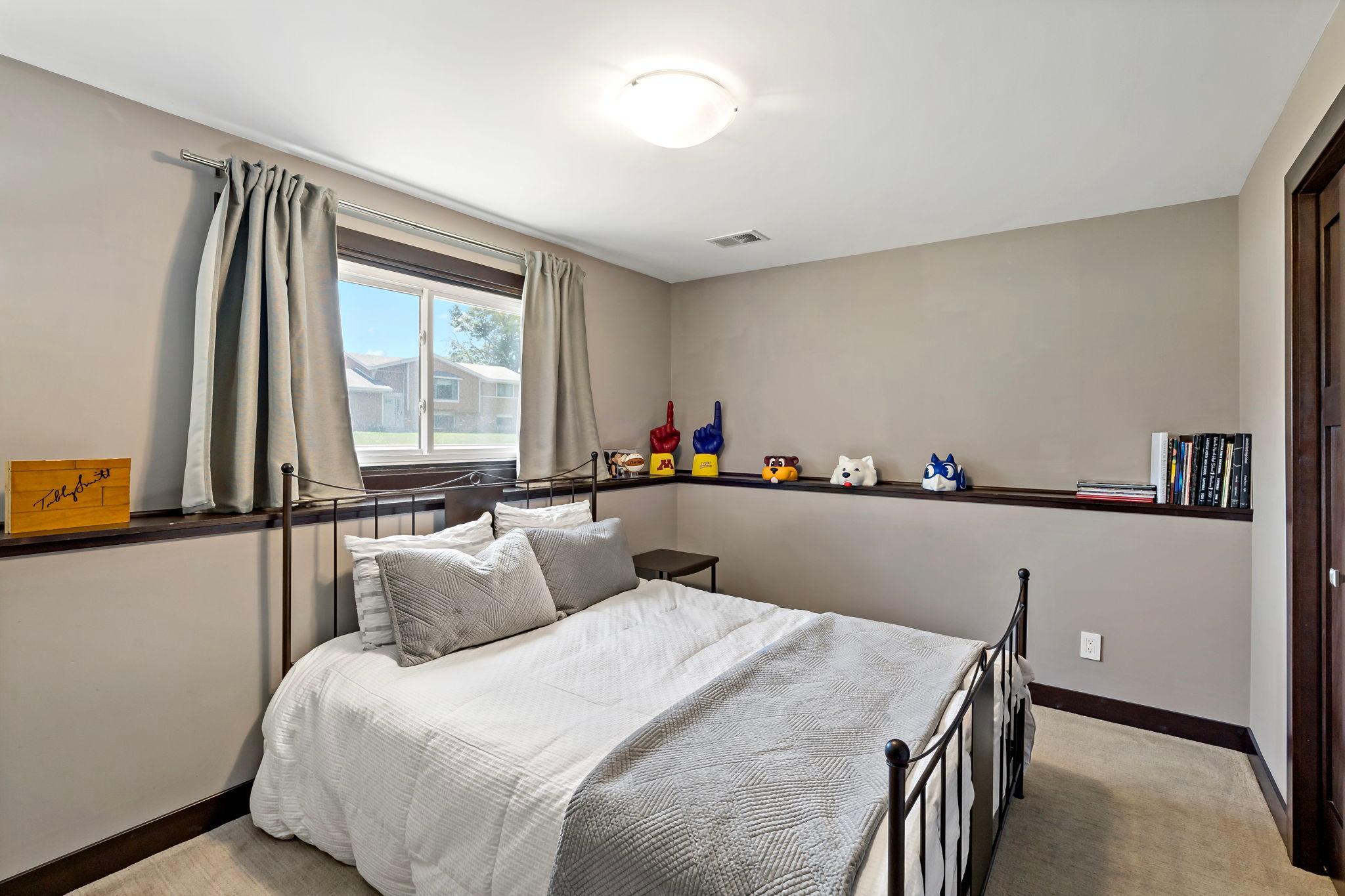 The lower level features a second bedroom with paneled wood doors and lower profile carpet