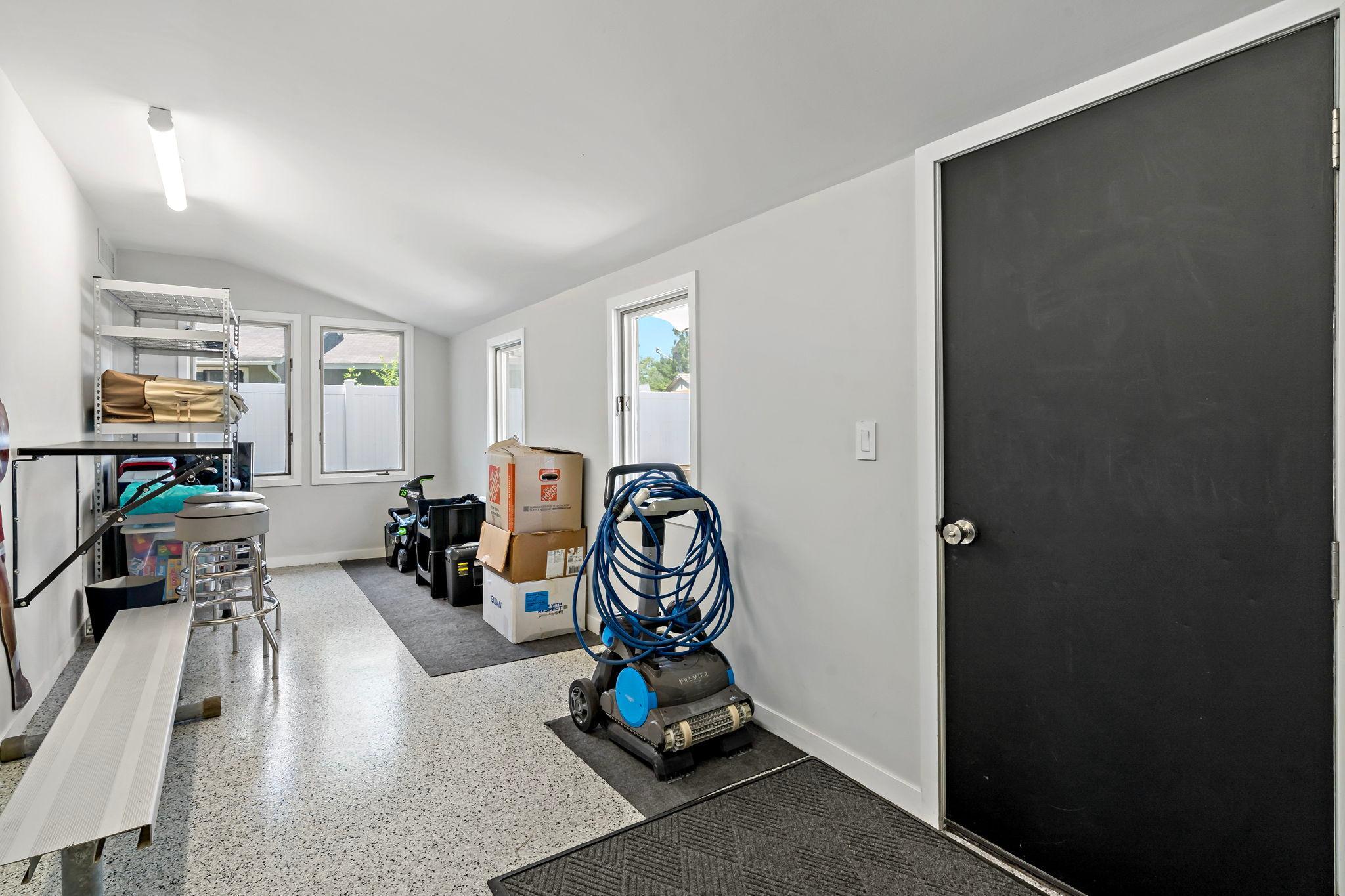 An additional finished storage space off of the garage (leading to the backyard) is fit for a workshop, pool storage, or gardening spot