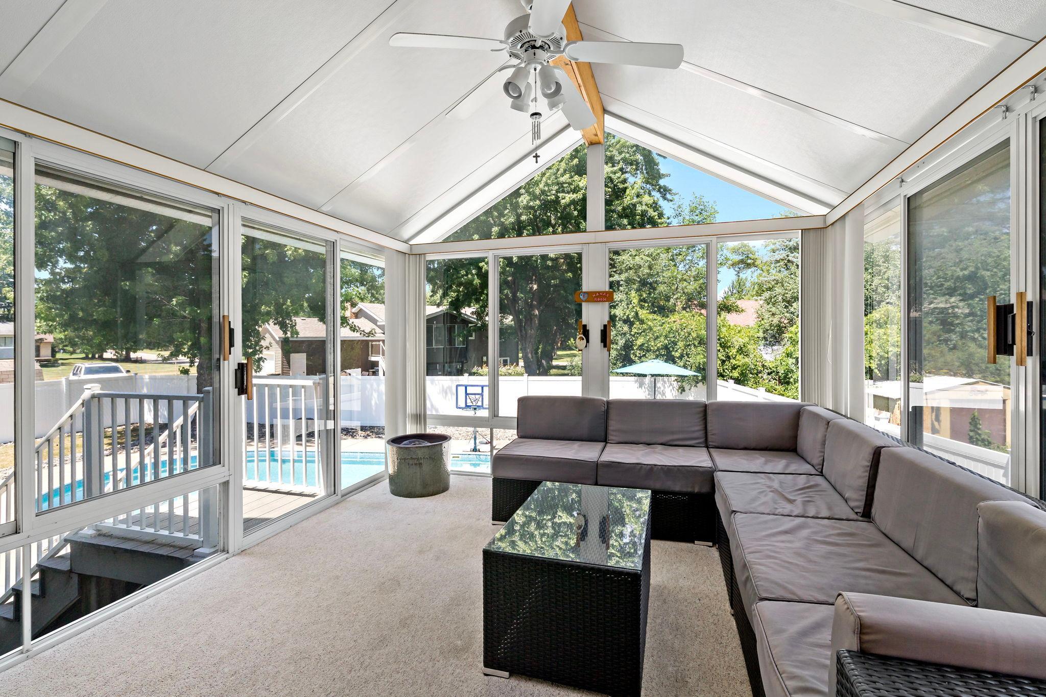 Relax in the sun-filled three-season porch overlooking the backyard oasis with direct access to the deck and in-ground pool