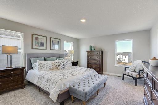 An oasis on it's own, the primary suite is both open and expansive, overlooks the back and is connected to a spacious primary suite bath and an oversized walk-in closet. Photo of model home, color and options will vary.