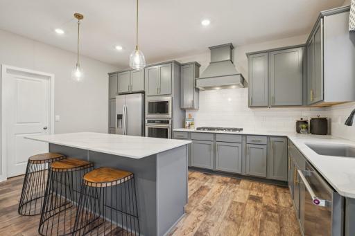 The kitchen is one of performance, and will feature Quartz countertops, stunning backsplash, durable flooring, a HUGE walk-in pantry & stainless appliances. Just an awesome set-up! Photo of model home, color and options will vary.