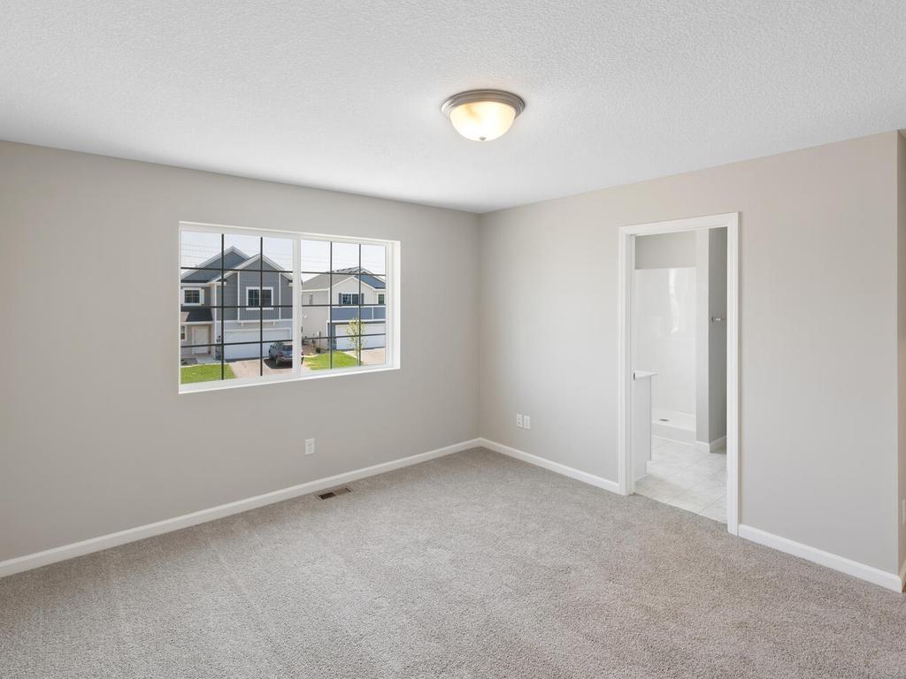 Primary Suite. Photo taken of another home with similar plan and finishes. Photos and renderings may not depict actual plan, materials, & finishes may vary. All measurements are approximate.
