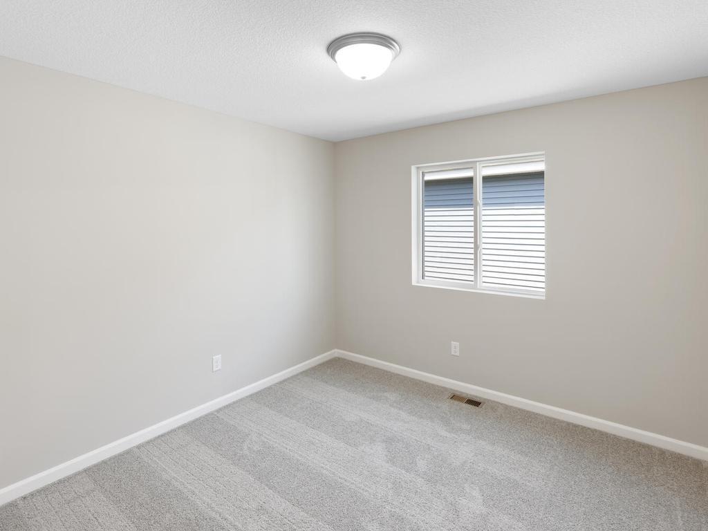 Bedroom 2. Photo taken of another home with similar plan and finishes. Photos and renderings may not depict actual plan, materials, & finishes may vary. All measurements are approximate.