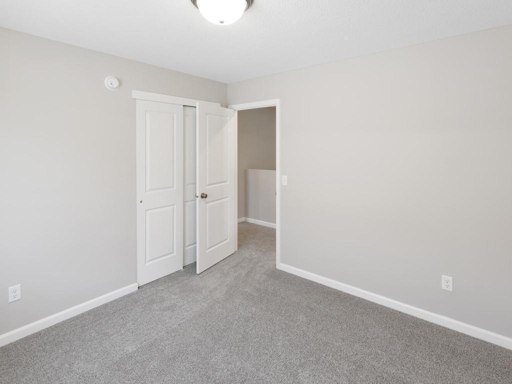 Bedroom 2. Photo taken of another home with similar plan and finishes. Photos and renderings may not depict actual plan, materials, & finishes may vary. All measurements are approximate.