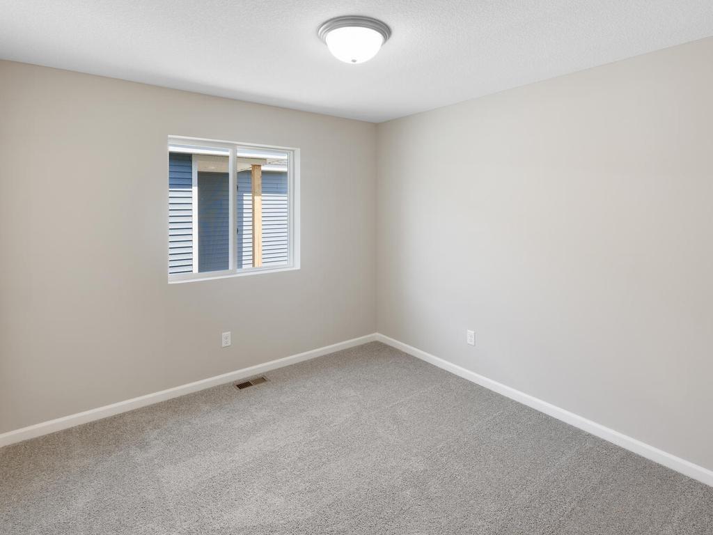 Bedroom 3. Photo taken of another home with similar plan and finishes. Photos and renderings may not depict actual plan, materials, & finishes may vary. All measurements are approximate.