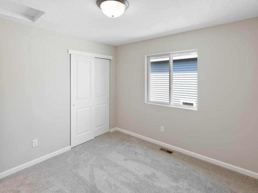 Bedroom 3. Photo taken of another home with similar plan and finishes. Photos and renderings may not depict actual plan, materials, & finishes may vary. All measurements are approximate.