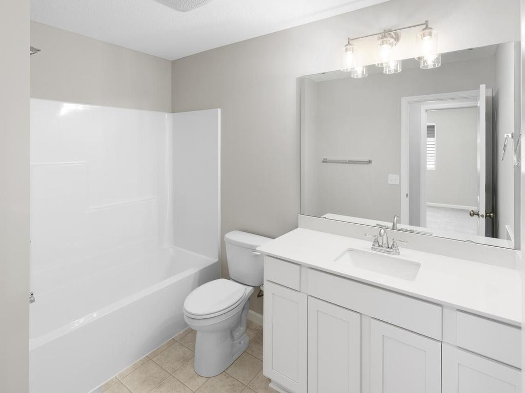 Hall Bath. Photo taken of another home with similar plan and finishes. Photos and renderings may not depict actual plan, materials, & finishes may vary. All measurements are approximate.