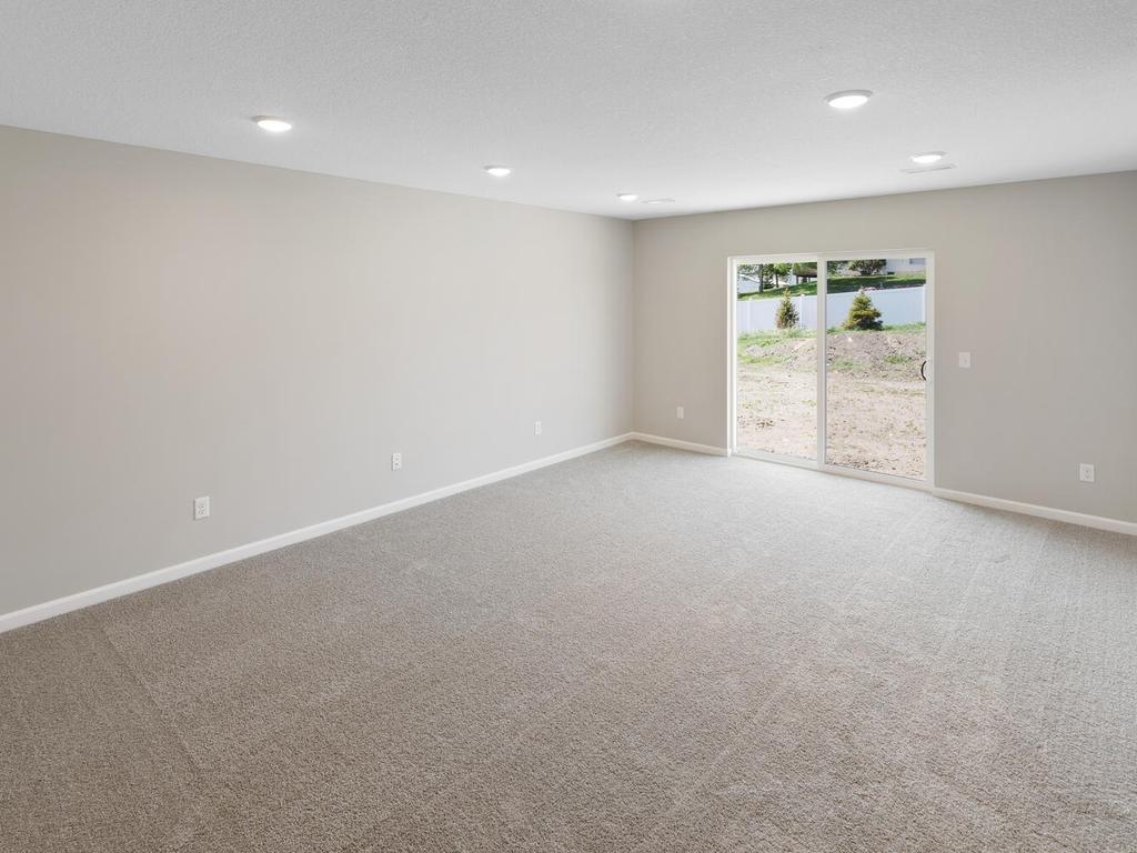 Lower Level Family Room. Photo taken of another home with similar plan and finishes. Photos and renderings may not depict actual plan, materials, & finishes may vary. All measurements are approximate.