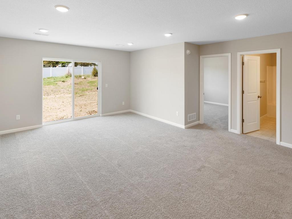Lower Level Family Room. Photo taken of another home with similar plan and finishes. Photos and renderings may not depict actual plan, materials, & finishes may vary. All measurements are approximate.