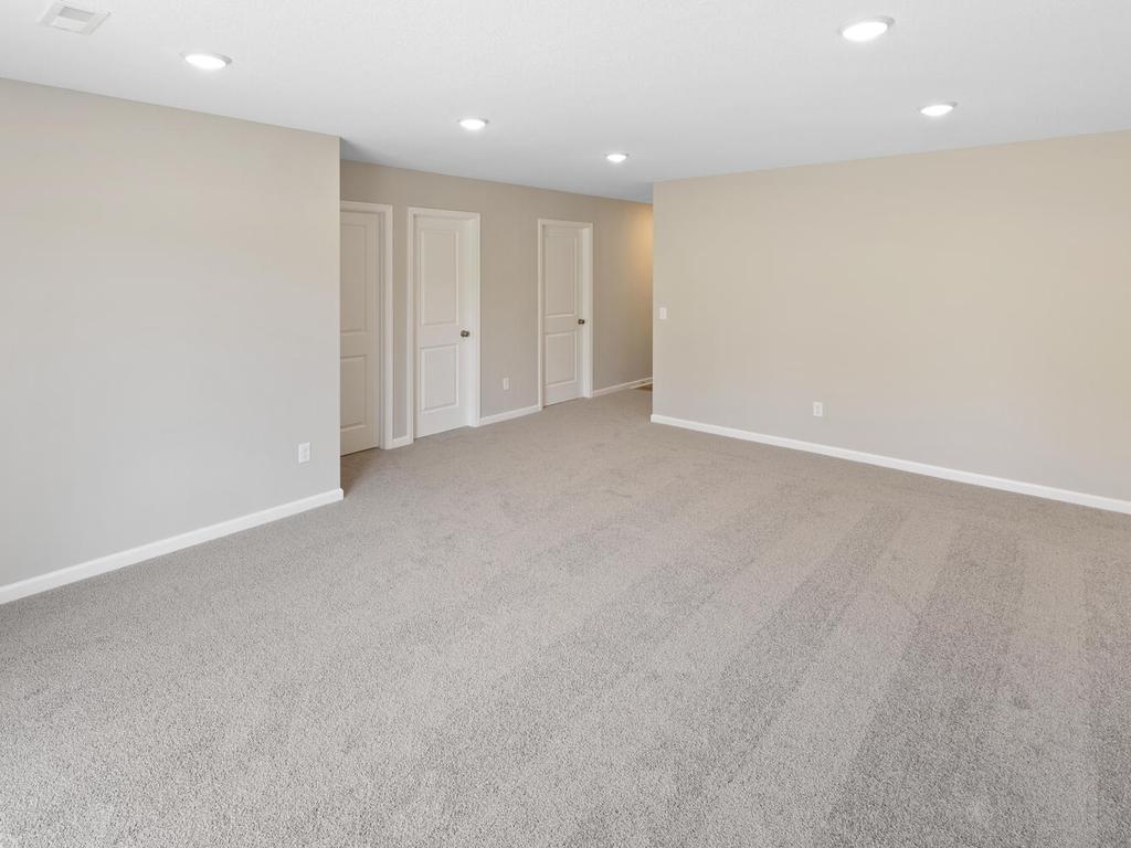 Lower Level Family Room. Photo taken of another home with similar plan and finishes. Photos and renderings may not depict actual plan, materials, & finishes may vary. All measurements are approximate.
