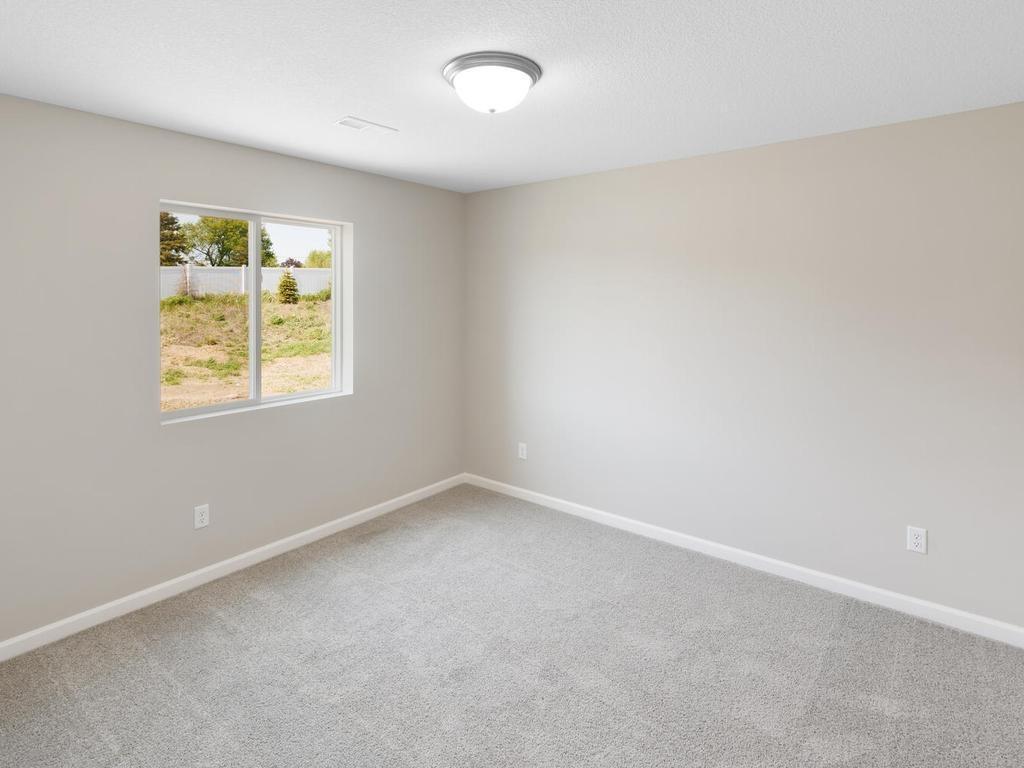 Lower Level Bedroom 4. Photo taken of another home with similar plan and finishes. Photos and renderings may not depict actual plan, materials, & finishes may vary. All measurements are approximate.