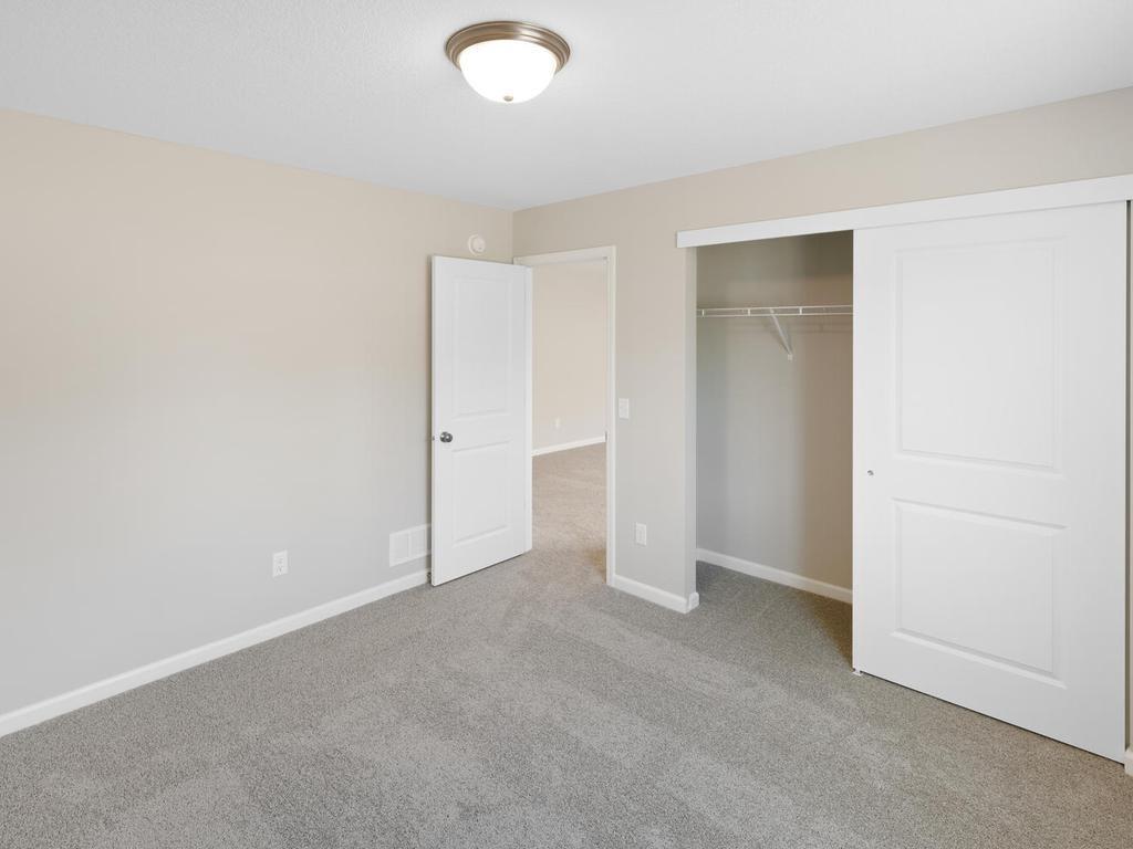 Lower Level Bedroom 4. Photo taken of another home with similar plan and finishes. Photos and renderings may not depict actual plan, materials, & finishes may vary. All measurements are approximate.