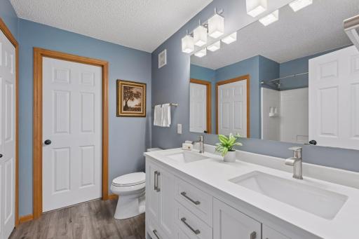 Primary bath with new vanity and LVP flooring in 2024. The seller changed the vanity set-up to add a 2nd sink. Updated lights and hardware. Linen closet is also in this room.