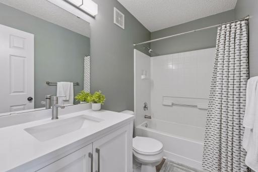 Full bath on upper level serves the 2 bedrooms. Updated vanity and flooring in 2024. Updated light fixture completes this beautiful bath.
