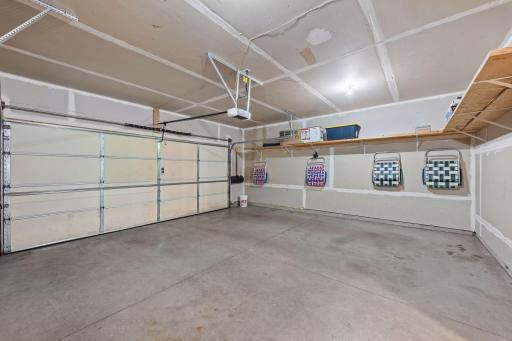 The garage is a little wider than 2 car which gives enough space for the trash cans and 2 cars. Shelving provides space to store totes and miscellaneous items above ground and out of the way.
