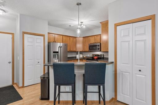 Guests can hang out at the breakfast bar while the cook is in the kitchen. The pantry is to the left of the fridge. The door to the right open of the bar opens to a closet and storage. Be sure to peek behind the coats.