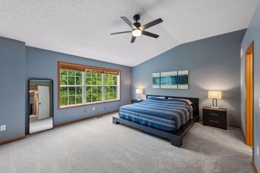Primary suite is enormous! The large windows provide a serene and private view out the front of the house. Newer wood slat blinds and ceiling fan. New carpet in 2024.