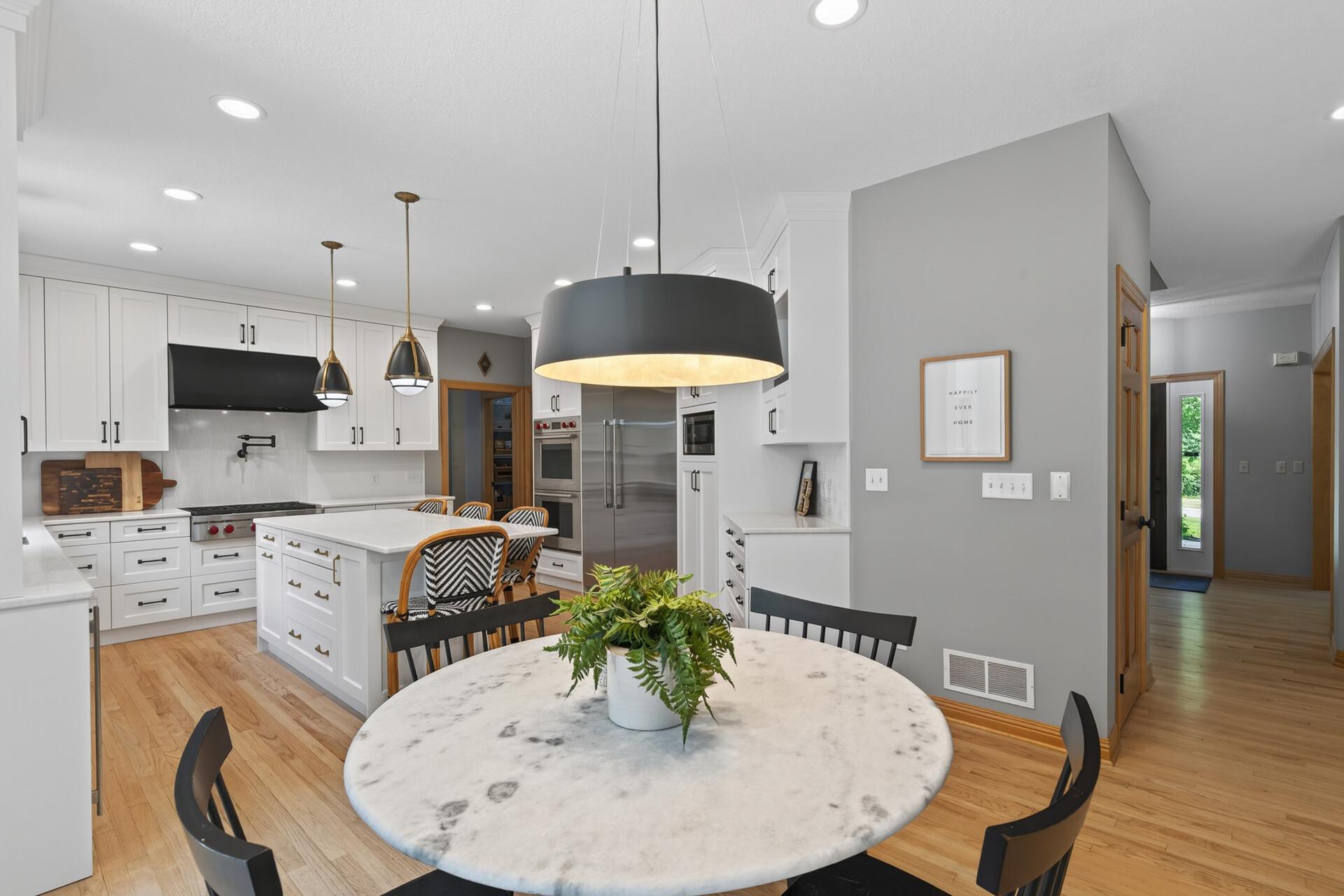 This designer kitchen truly has it all; a beautiful eat-in dining area, a massive island with breakfast bar, and a layout that makes every meal feel like an occasion. Thoughtfully chosen lighting fixtures throughout.