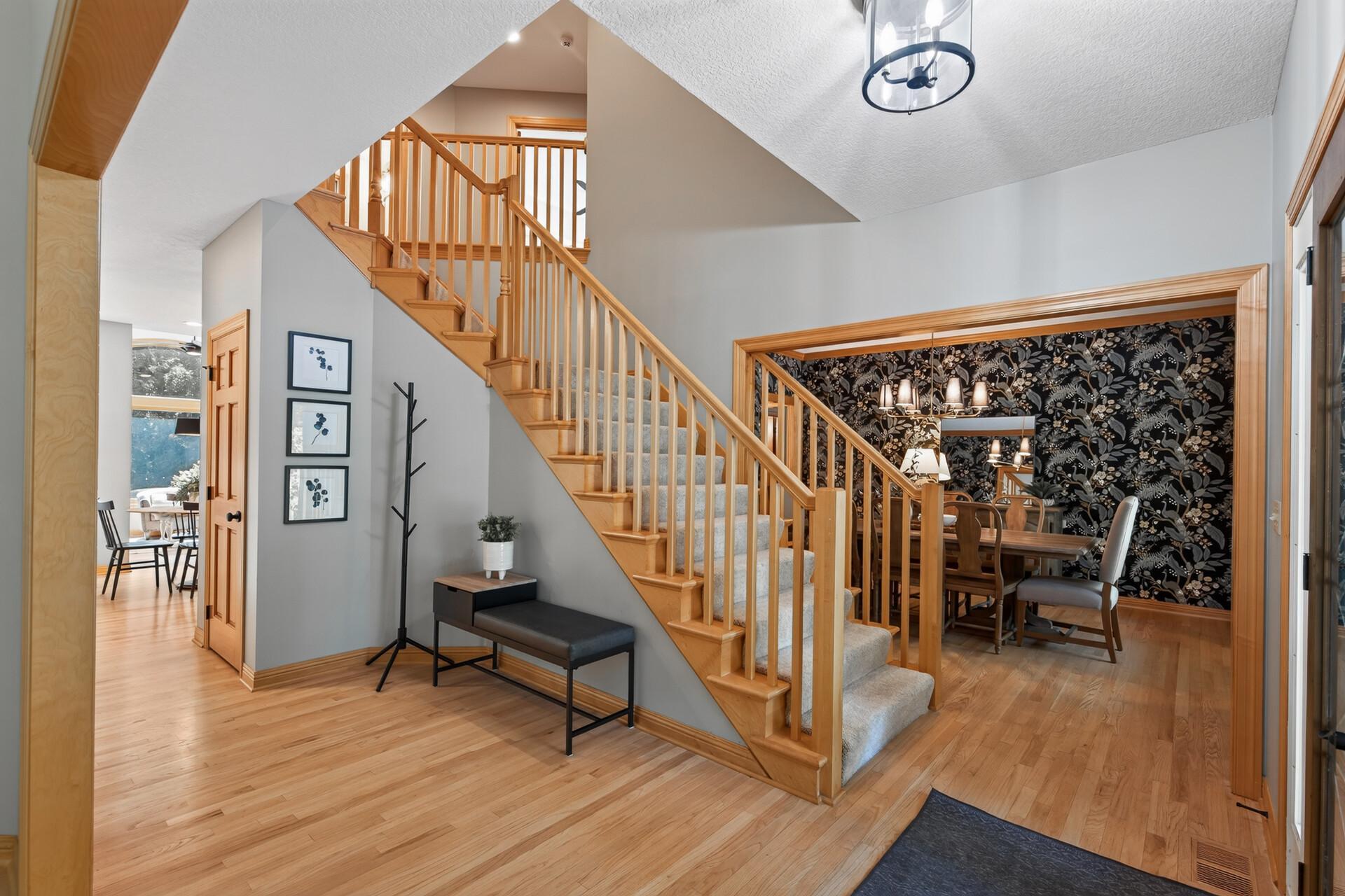 A grand, inviting entryway welcomes you with soaring ceilings, a dedicated coat closet, and a beautiful staircase that draws you right into the heart of this extraordinary home.