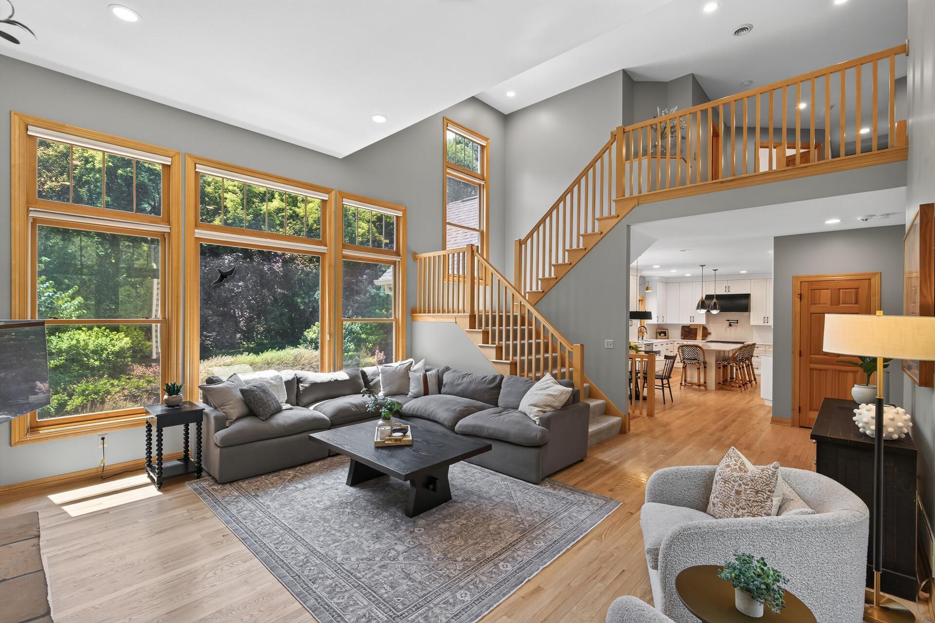 Soaring two-story ceilings meet floor-to-ceiling windows in this breathtaking living room; natural light pours in from every angle creating a bright, airy, and truly magnificent space that has to be experienced in person.