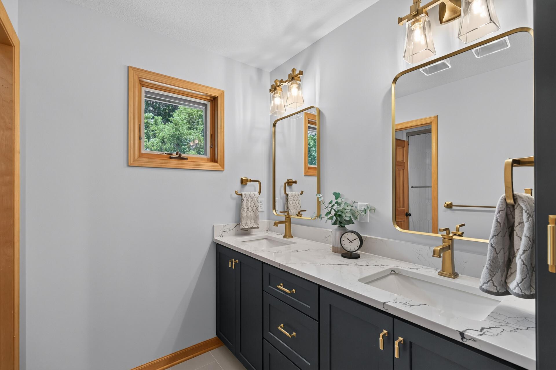 Three bedrooms, one beautifully designed full bathroom; custom tile, gold accents, and designer finishes that remind you this home never cuts corners, not even here.