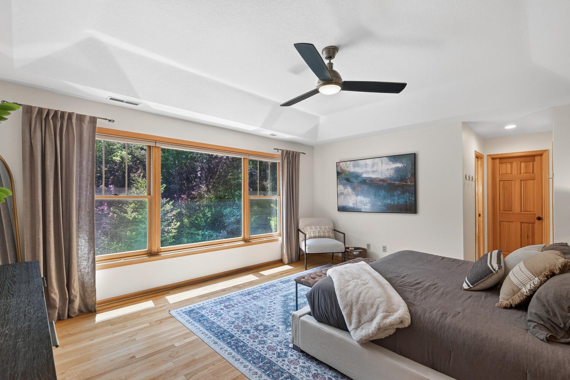 This primary bedroom windows frame a spectacular resort-style backyard view that you will wake up to every single morning. Custom tiered ceiling elevate this space!