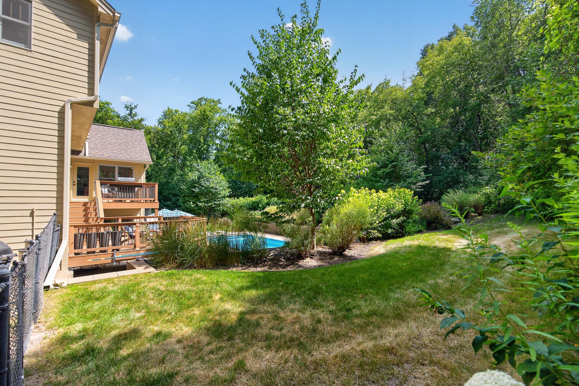 From this angle the full scope of the outdoor living experience comes into view; a gorgeous multi-tiered deck, a resort-style pool, and professionally landscaped grounds that together create something you simply cannot find anywhere else.