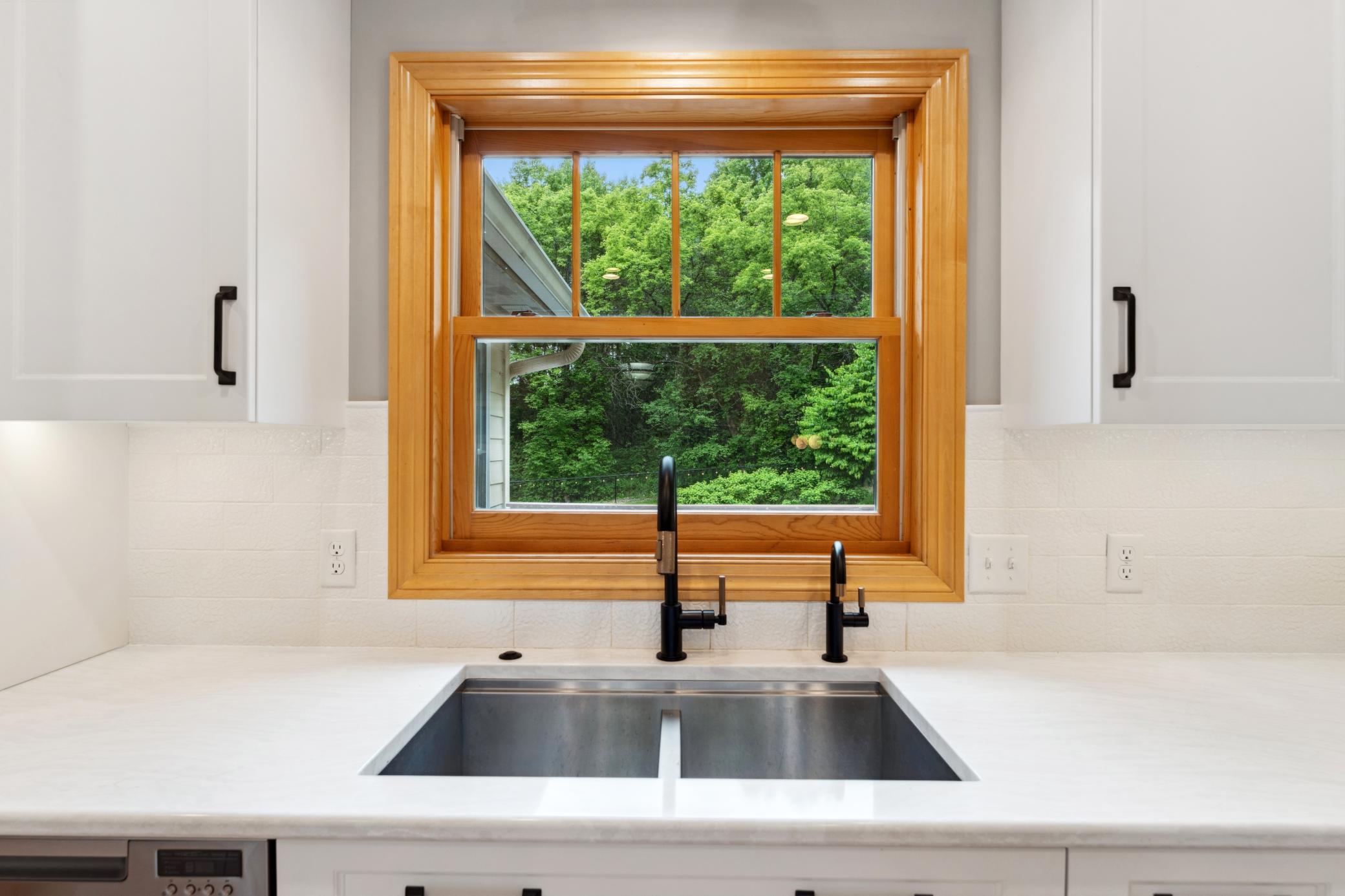The kitchen window frames a gorgeous view while the upgraded designer faucets make this kitchen sink a showstopper in its own right; proof that every single detail in this kitchen was chosen with care. Water infiltration system included with home.