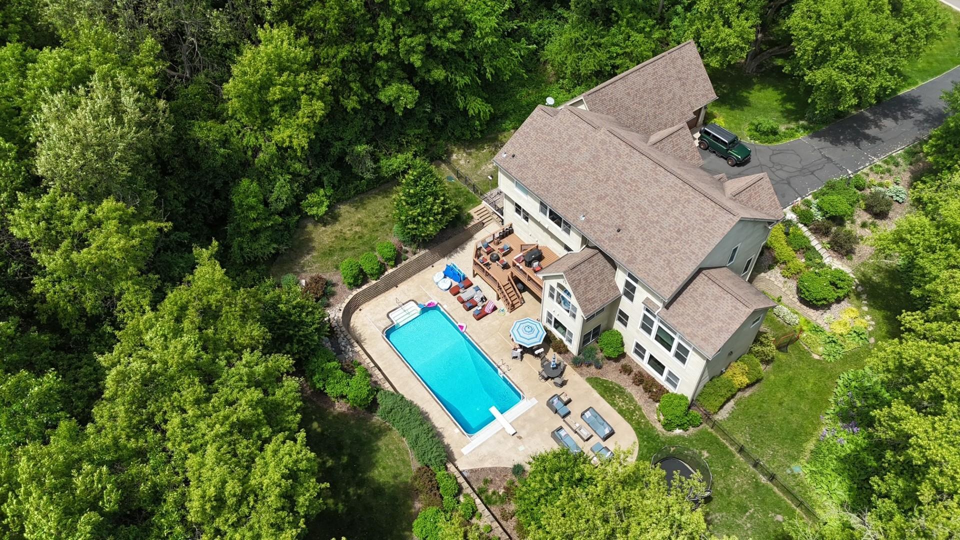 From above, the true magnitude of this 3-acre estate comes into view; lush professional landscaping, a private wooded backdrop, and a fenced backyard, it is a property that delivers the ultimate in privacy and entertainment.