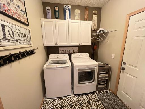 Main floor laundry off garage with cabinets.