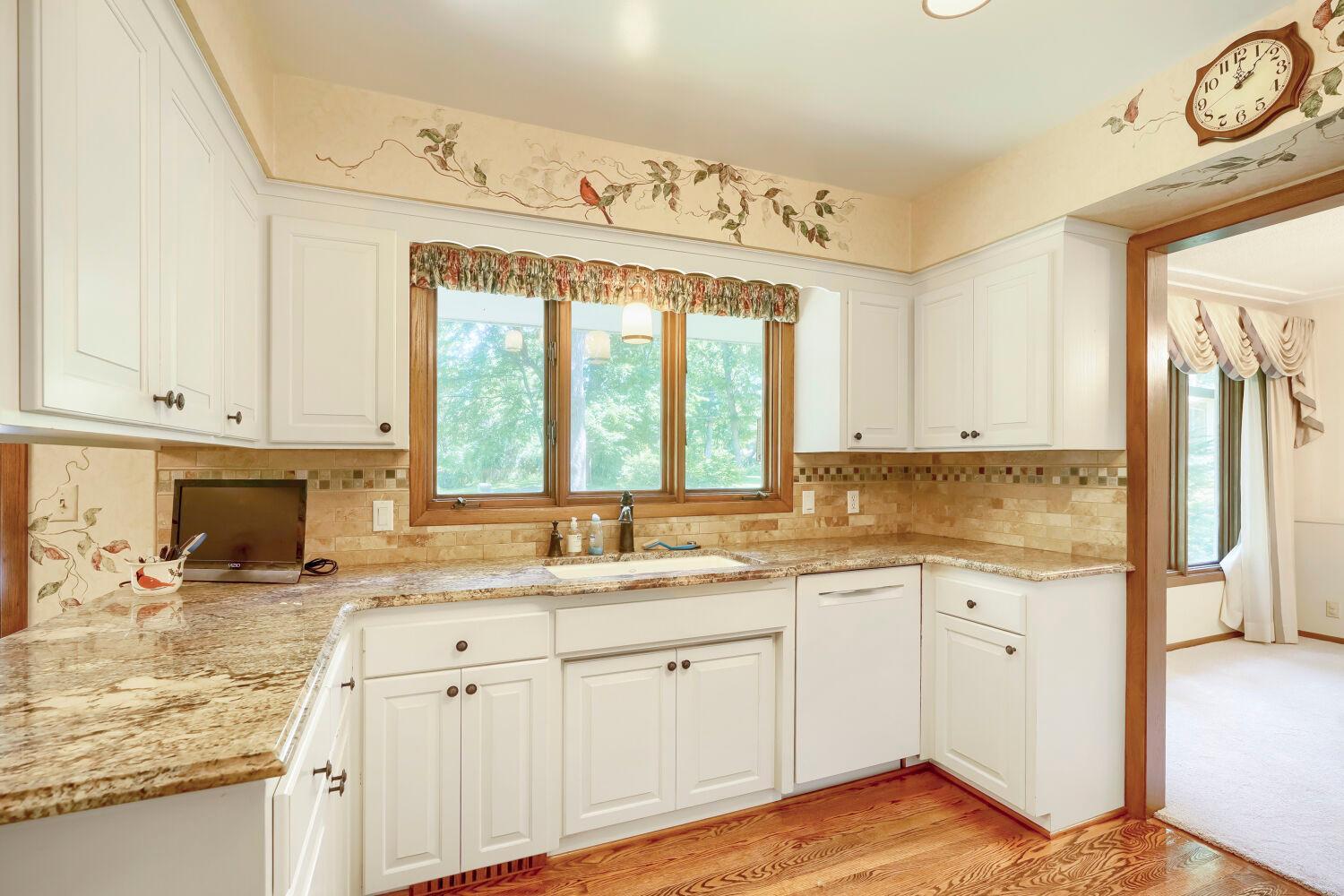 Kitchen features bright white cabinets and hard surface countertops.