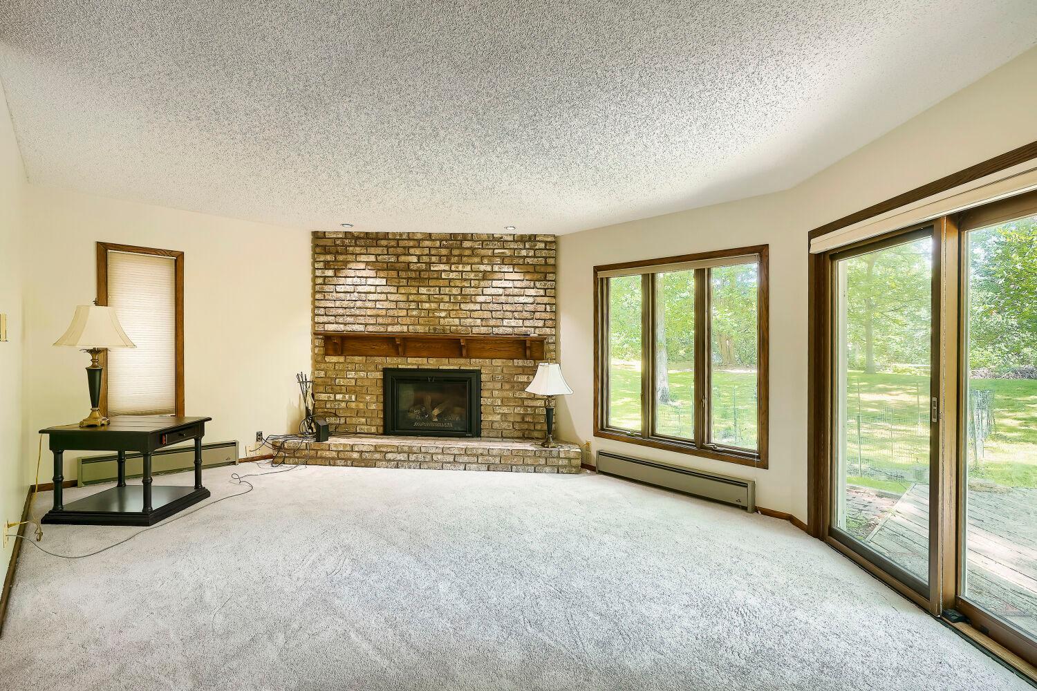 Family room with wood burning fireplace and sliding glass door to walkout