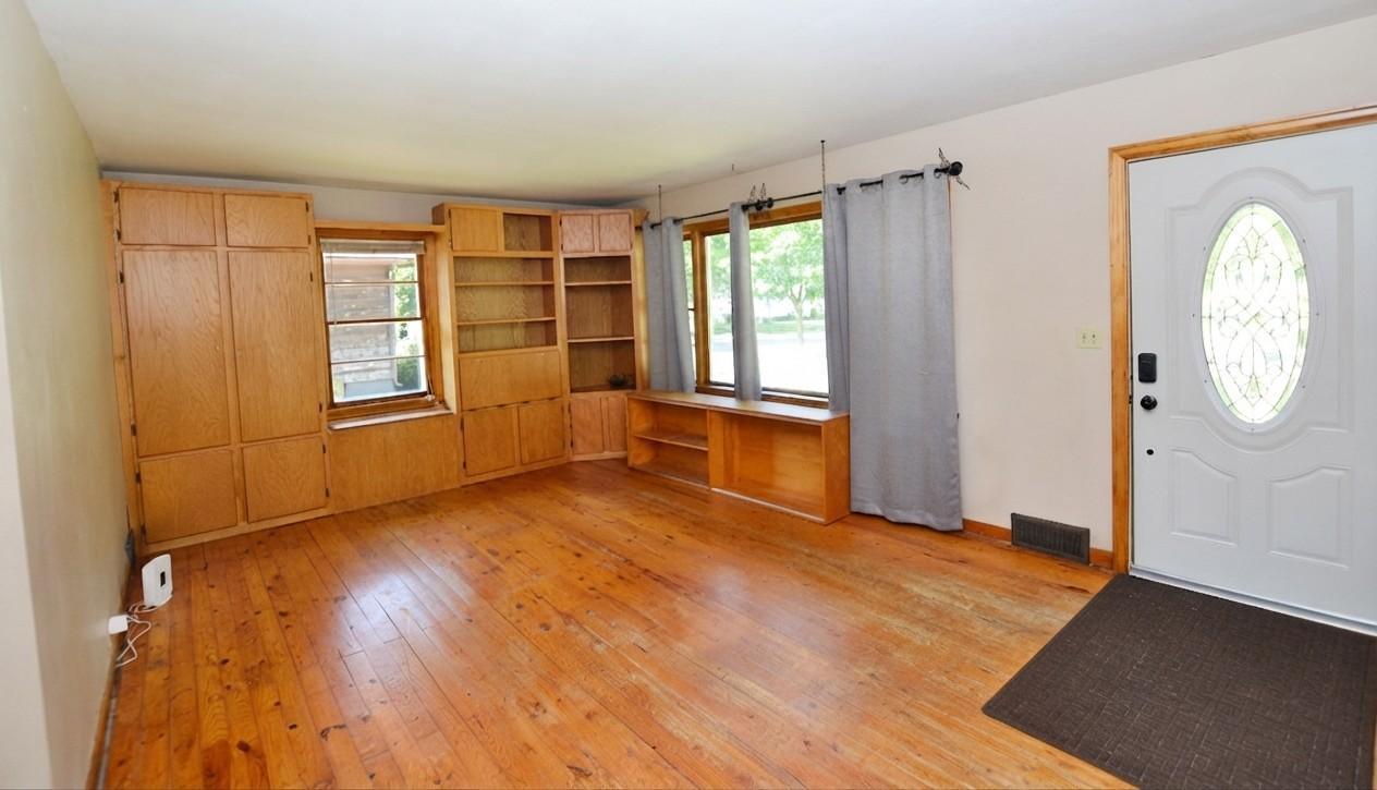 Main floor living room with wood floors & nice built-ins.