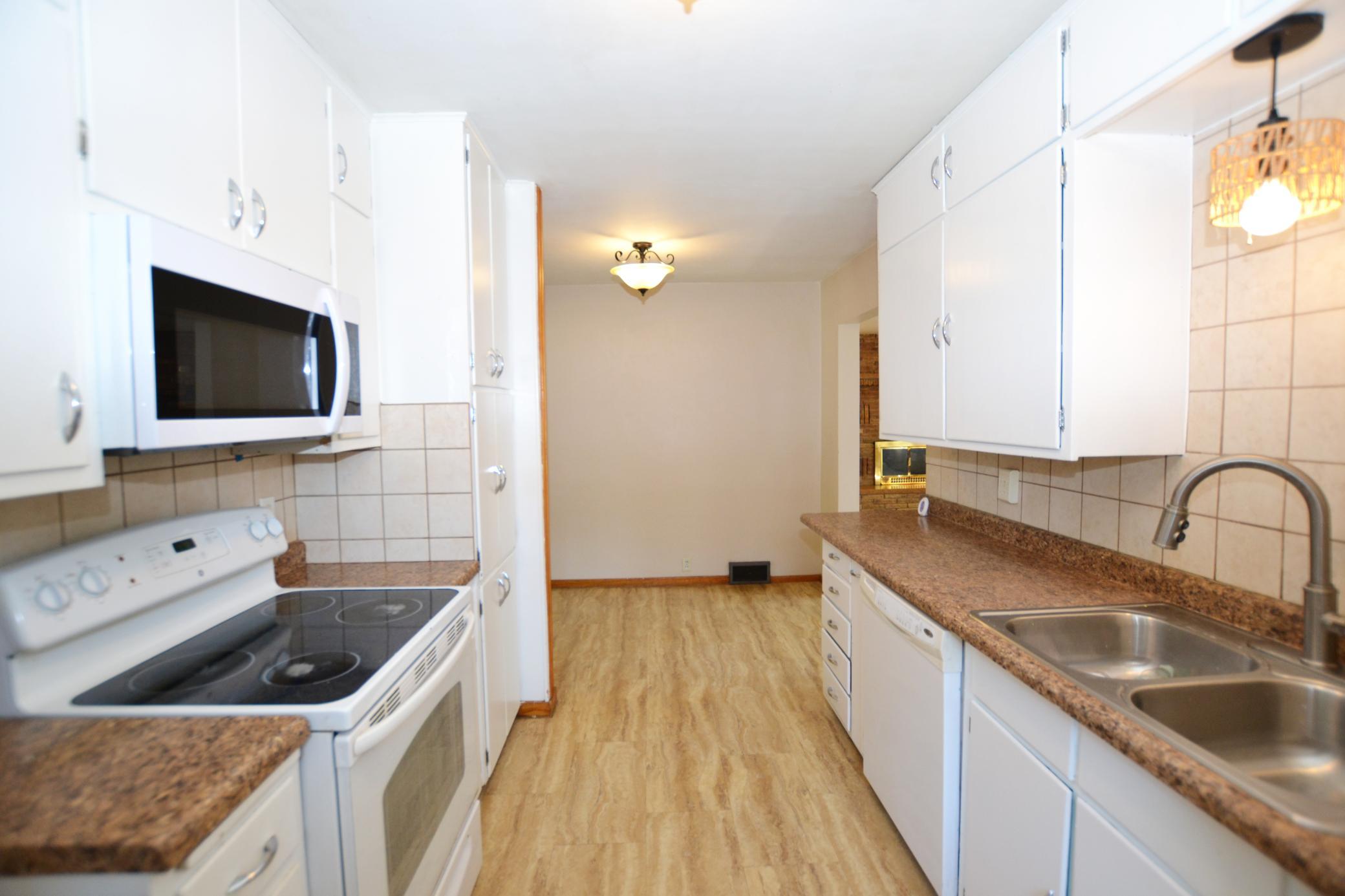 Freshly painted cabinets with trendy counters & tile back splash.