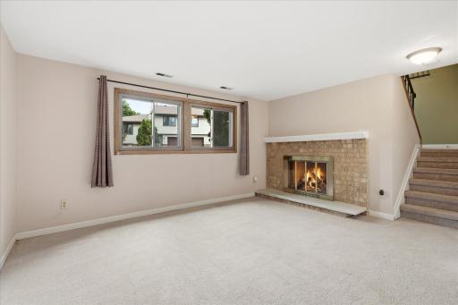 Lower level family room with cozy wood burning fireplace.