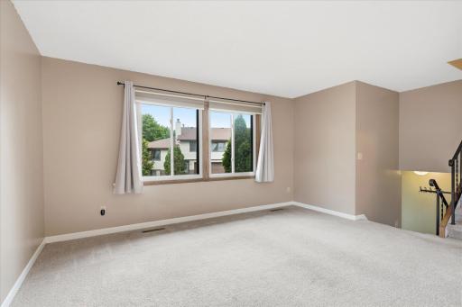 Living room with stairs to upper level & bedrooms to the right.
